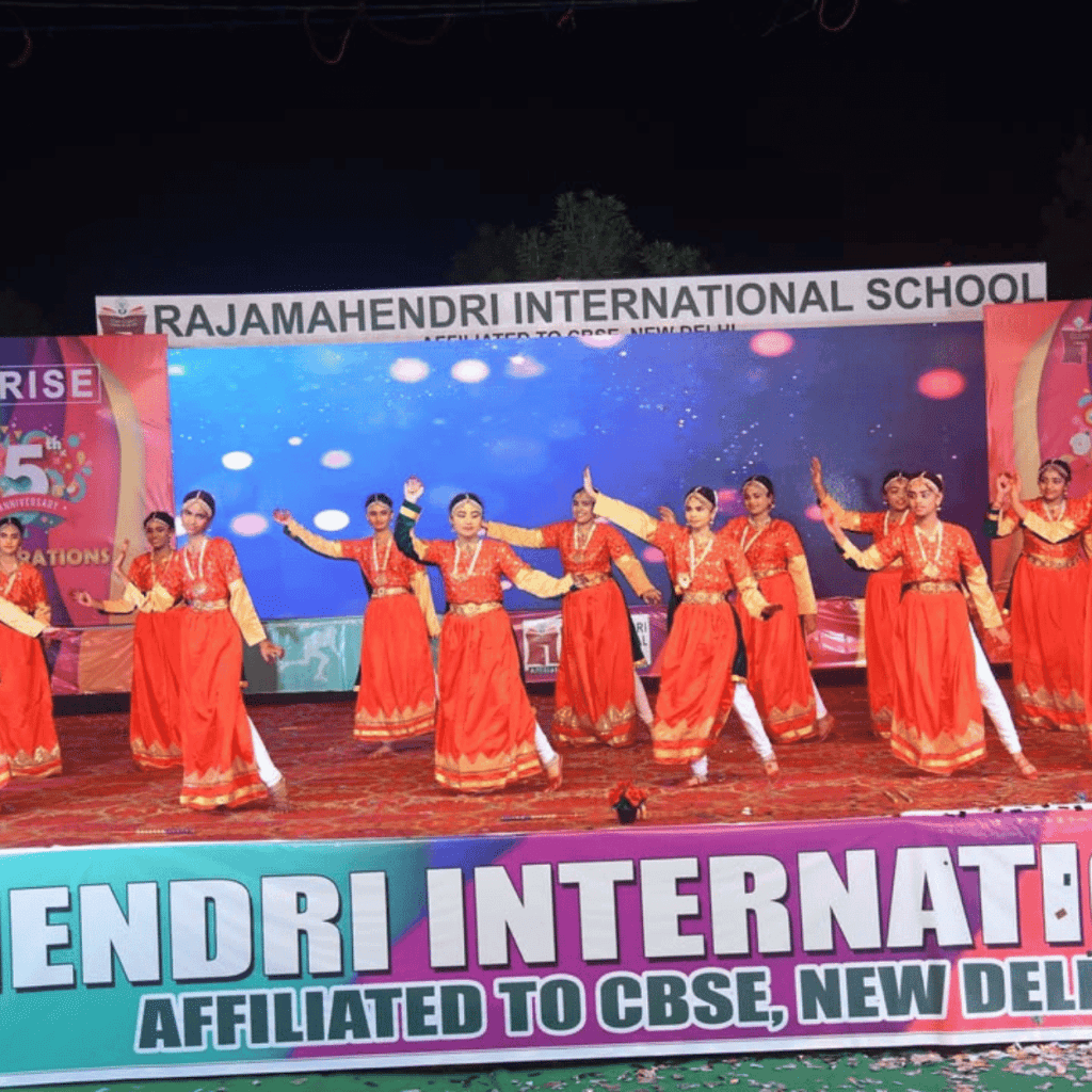 Girls performing a dance on stage during a school 5th anniversary celebration